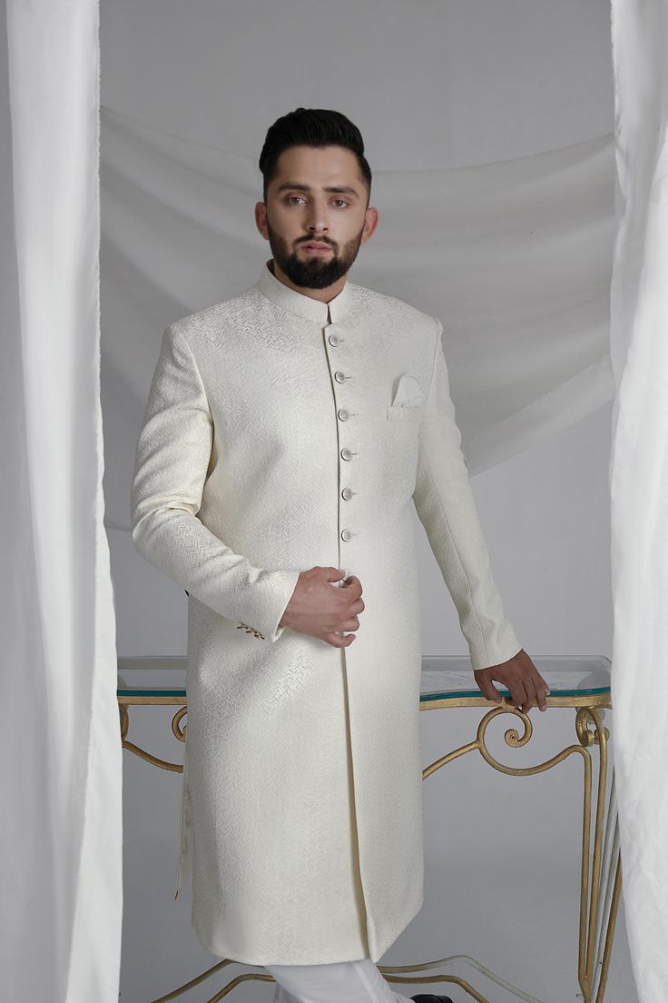 This White Long Sherwani is a stunning choice for your special occasion. Made from printed off-white khaadi silk, it features a silk kurta and cotton pajama for a comfortable fit. Complete your look with the elegant organza Rajastjhani kula (turban) and exude an air of style and sophistication. Off White Traditional Wear With Dabka For Designer Occasions, Cream Cotton Silk Traditional Wear For Wedding, Elegant Cotton Silk Kurta With Cutdana, Fitted White Cotton Silk Kurta, White Embroidered Cotton Silk Bandhgala, White Fitted Cotton Silk Kurta, Embroidered White Cotton Silk Bandhgala, White Cotton Silk Bandhgala With Resham Embroidery, Elegant Cream Cotton Silk Traditional Wear