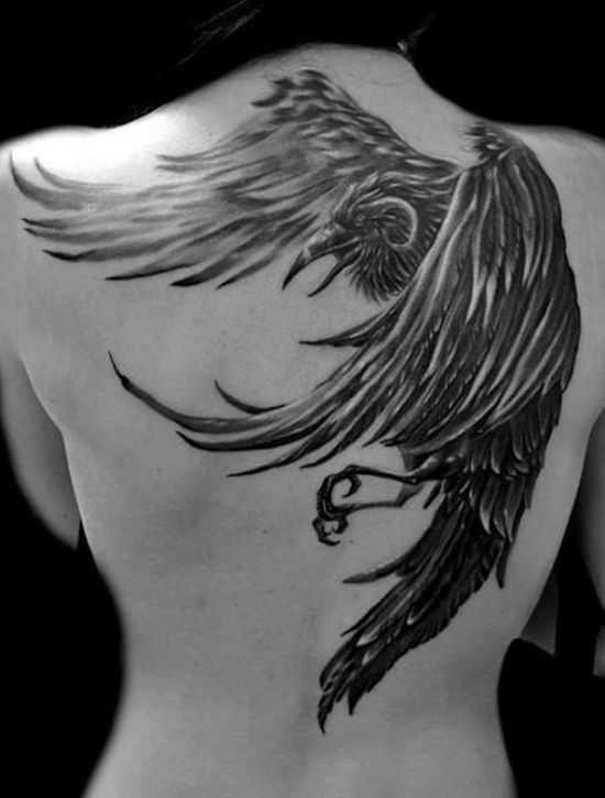 the back of a man's shoulder with a black and grey tattoo design on it