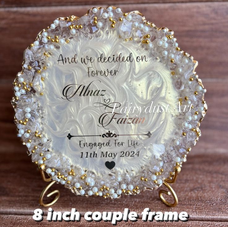 an ornate glass plate with pearls and gold trimmings on the edges is shown in front of a wooden background