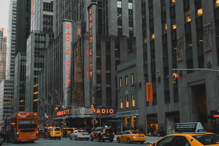 a busy city street filled with lots of traffic and tall buildings in the evening hours