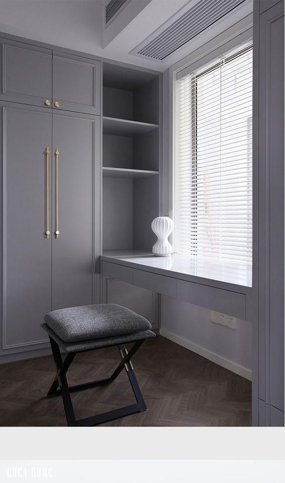 a white vase sitting on top of a window sill next to a desk and chair