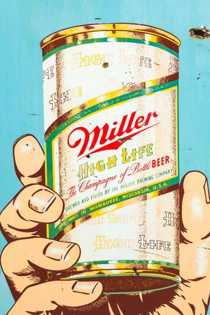 a hand holding a can of miller high life beer