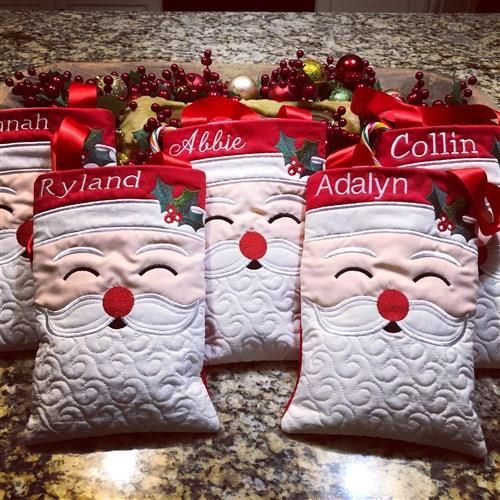 four personalized christmas stocking pillows on a counter