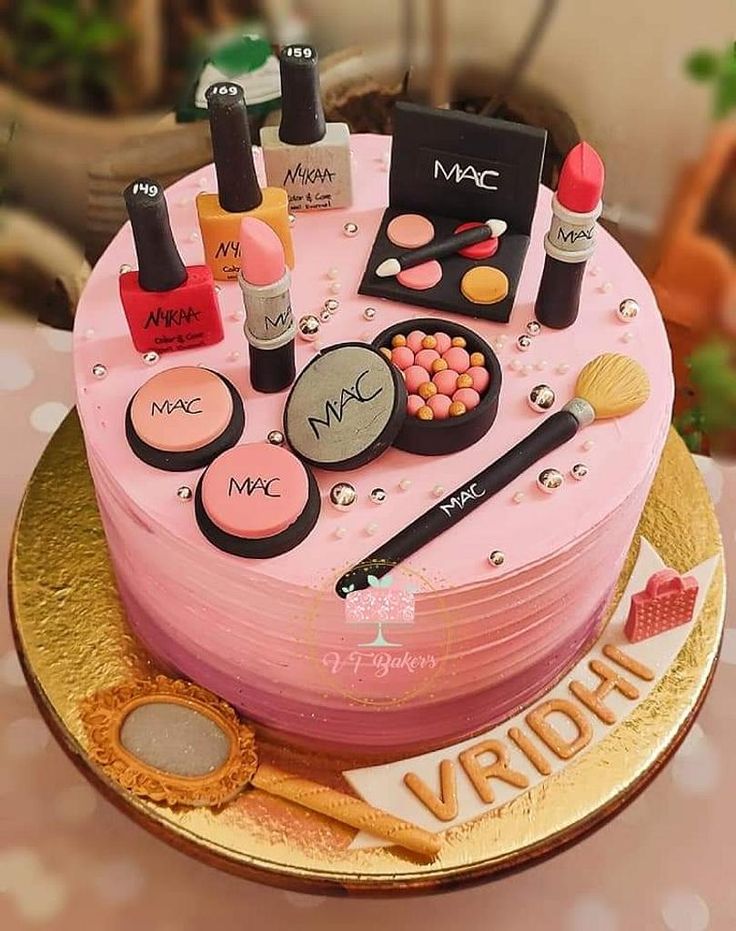 there is a cake with makeup and cosmetics on the top, along with other items