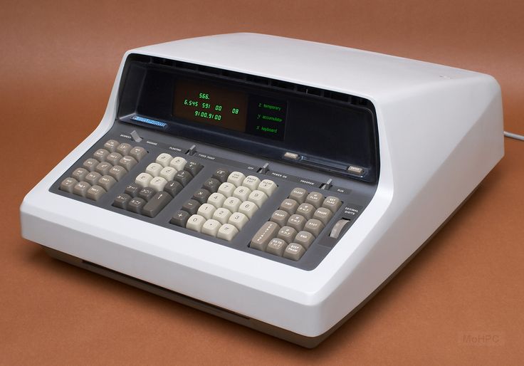 an old style calculator sitting on top of a white table with buttons and numbers