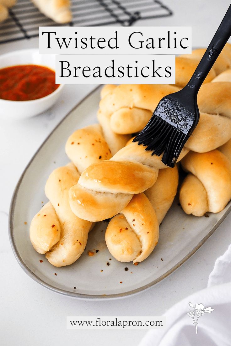 twisted garlic breadsticks on a plate with a brush