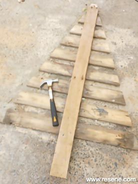 a wooden pallet sitting on top of a cement floor next to a wrench