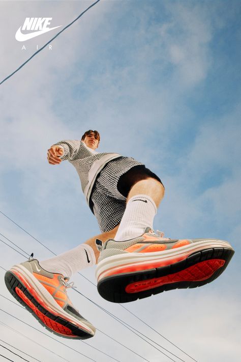 a man flying through the air while riding on top of a pair of nike shoes