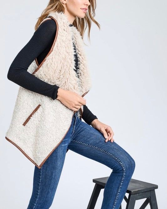 Sherpa vests are always the cutest during fall and winter, especially over a pair of long sleeves, denim jeans, and boots! Take our advice and grab a hold of this vest that features a super soft and cozy wool blend, open front, fold over collar, two functional side pockets, and a faux leather trim. color: beige tone ivory + tan acrylic/wool/polyester blend imported professionally clean Fall Sweater Vest With Pockets For Layering, Fall Layering Sweater Vest With Pockets, Beige Vest For Cold Weather In Fall, Trendy Fall Sweater Vest For Everyday, Trendy Winter Sweater Vest For Everyday, Trendy Sweater Vest For Everyday Fall Wear, Trendy Everyday Winter Sweater Vest, Sleeveless Vest For Cold Weather In Fall, Beige Fall Sweater Vest With Pockets