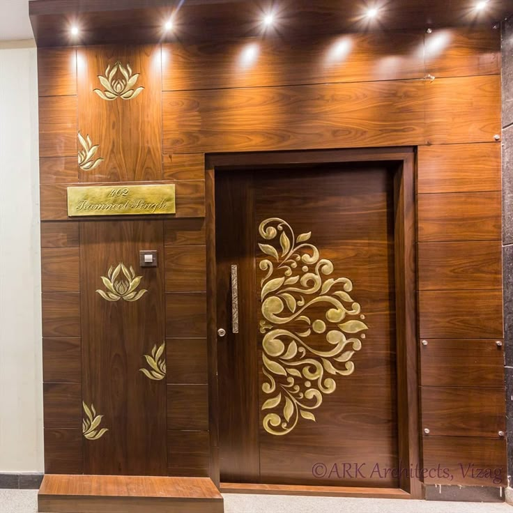 an entrance to a building with wooden doors and decorative designs on the wall above it