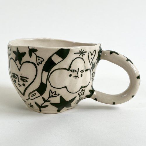 a ceramic cup with black and white designs on it