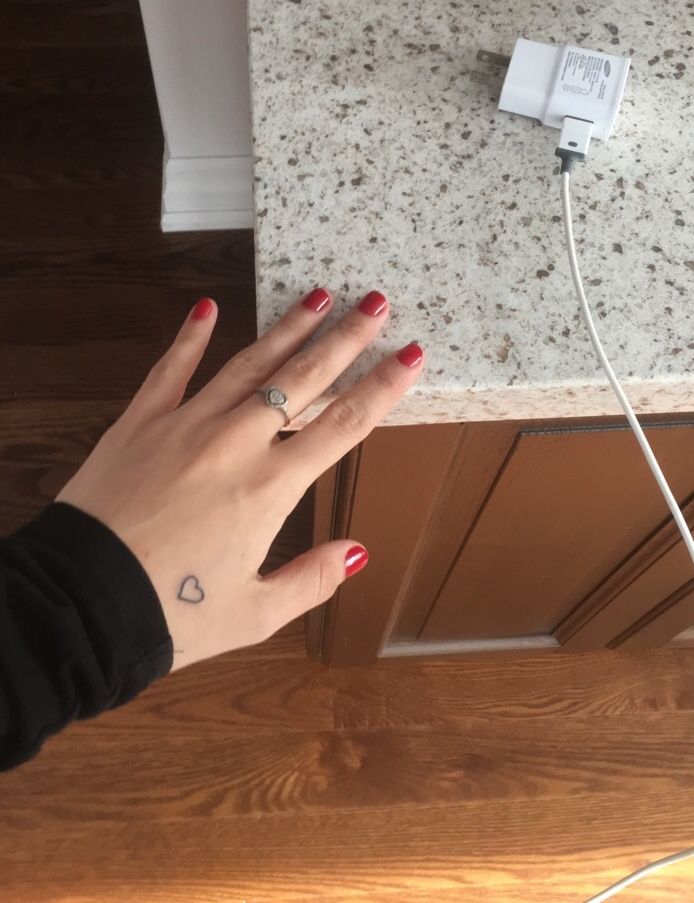 a woman's hand with a ring on her finger next to an electrical outlet