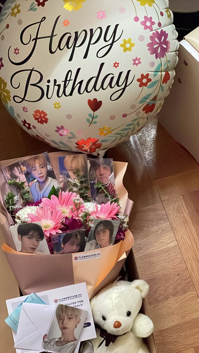 a bunch of flowers and pictures in a box with a balloon that says happy birthday