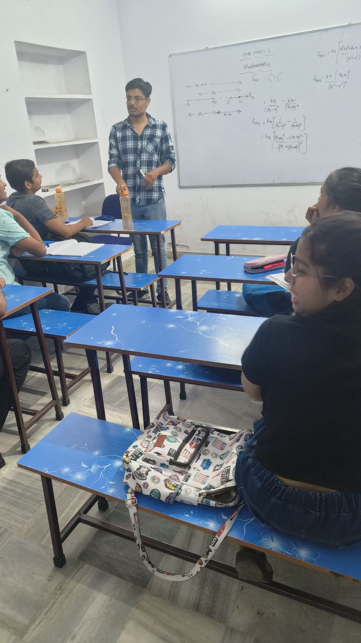 a group of people sitting at desks in a classroom