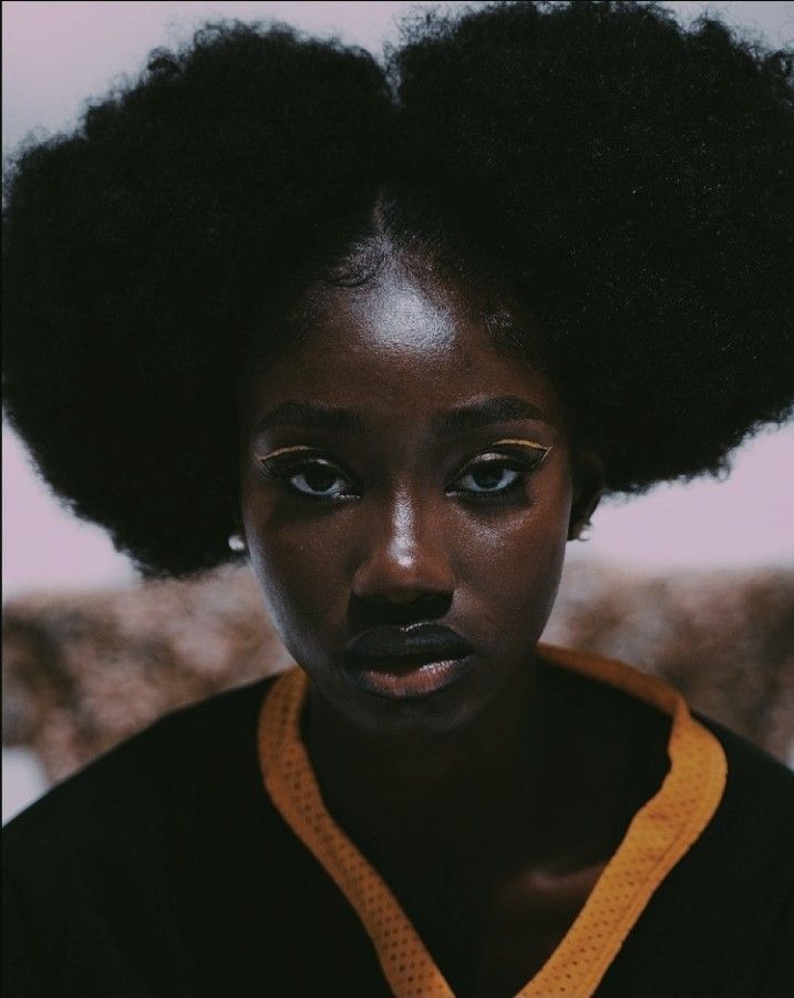 a woman with an afro is looking at the camera