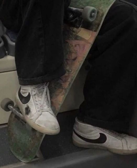 a skateboarder with his foot on the edge of a ramp while holding his board