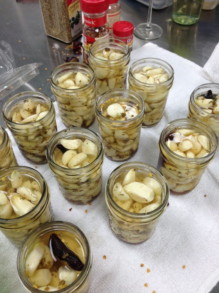 several jars filled with pickles sitting on top of a table