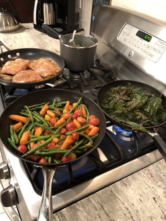 three pans filled with food sitting on top of a stovetop next to an oven