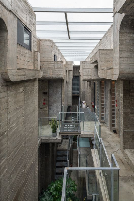 the inside of a building with stairs leading to another building and plants growing in it