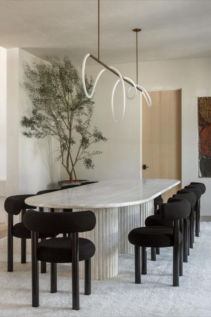 an elegant dining room with white marble table and black chairs