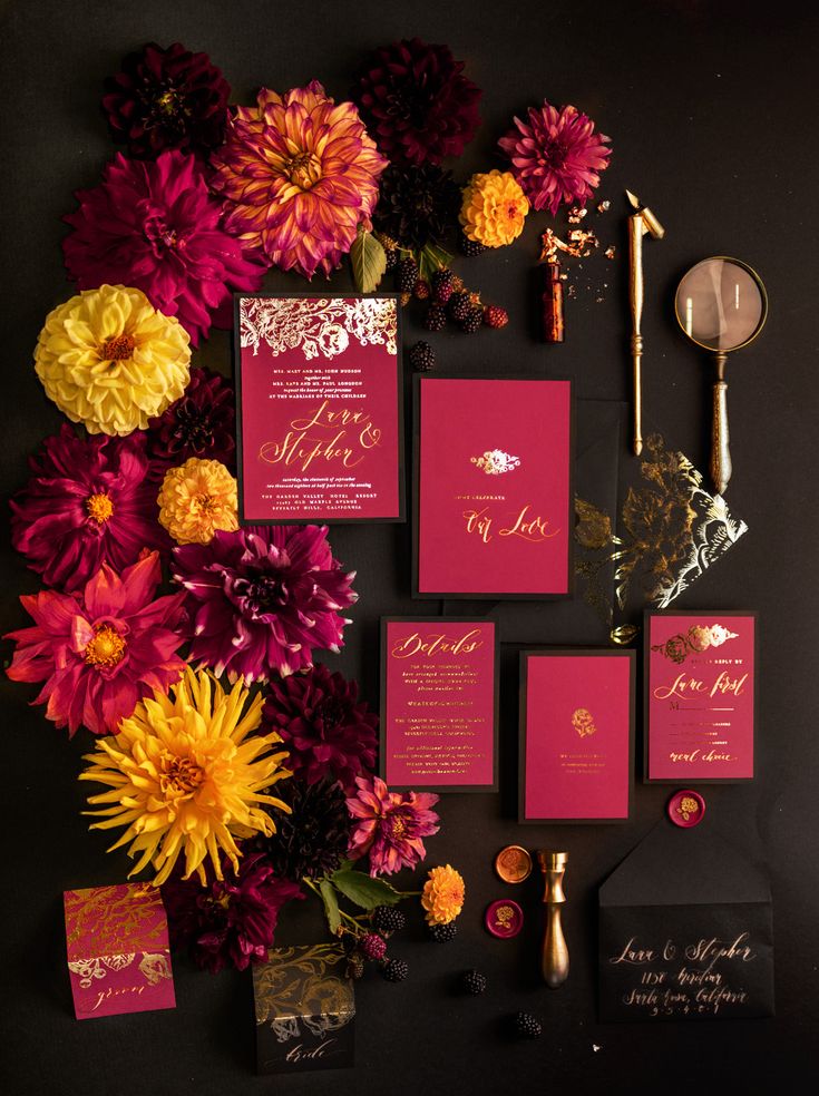 the wedding stationery is surrounded by flowers