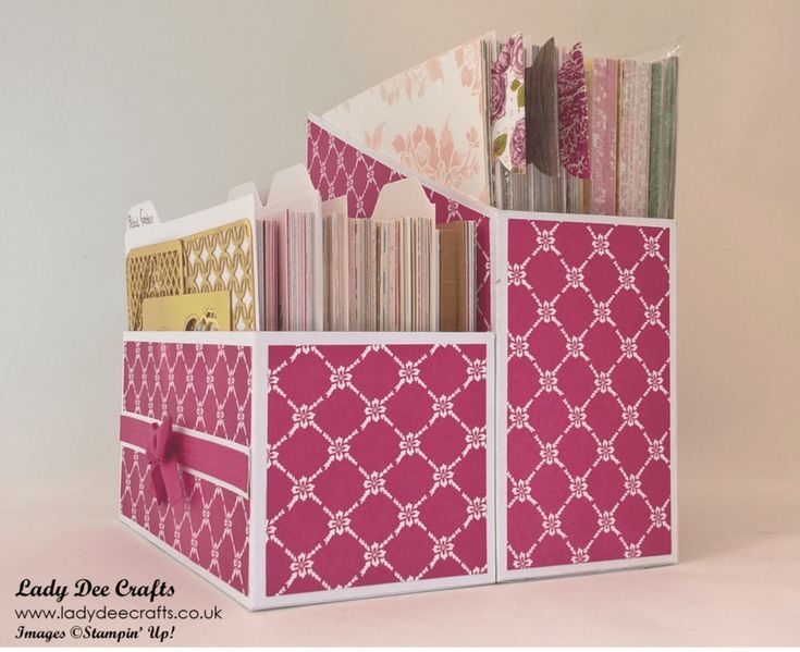 a pink and white storage box filled with lots of papers