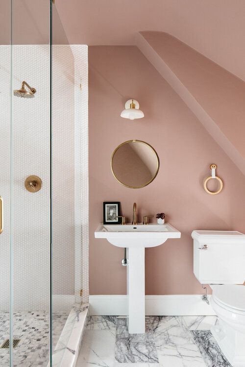 a bathroom with pink walls and marble flooring