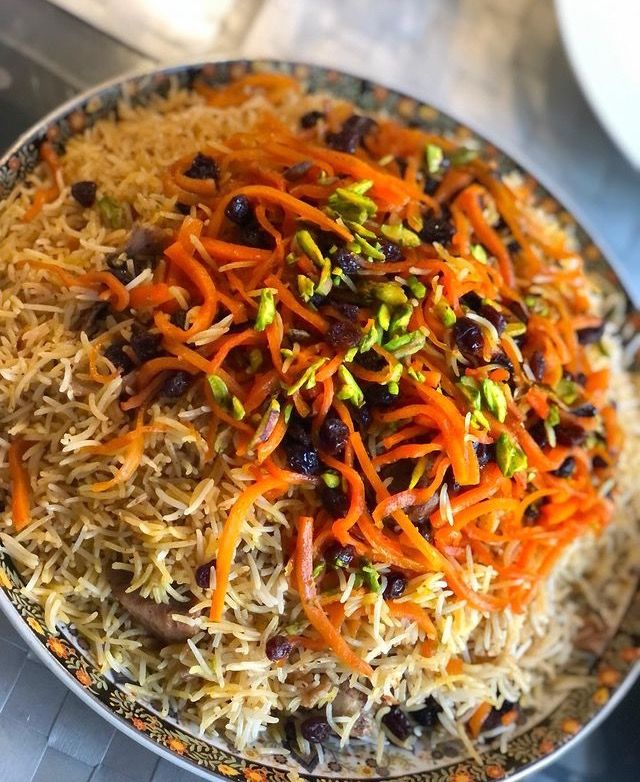 a bowl filled with carrots, raisins and sprouts