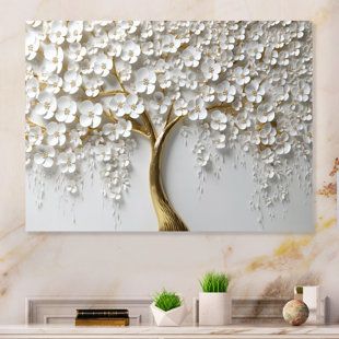 a white tree with lots of flowers on it in front of a wall mounted art piece