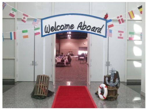 an entrance to a building with a red carpet on the floor and welcome sign above it