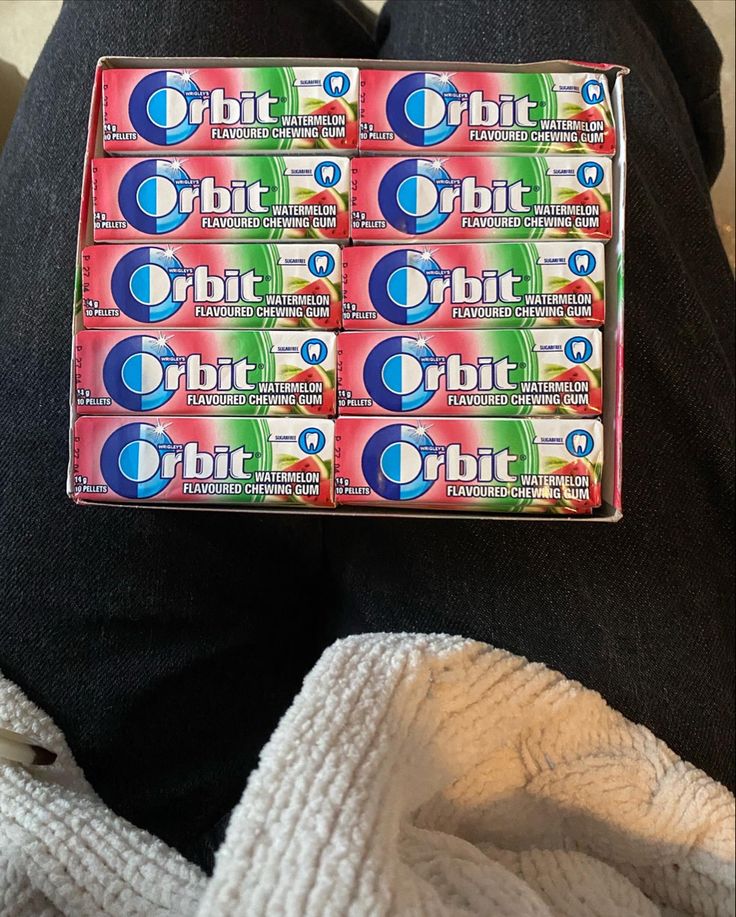 a box of toothpaste sitting on someone's lap