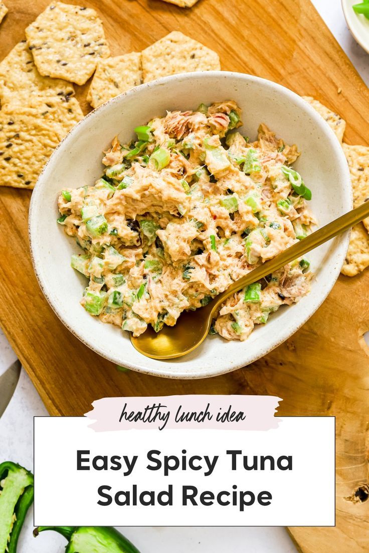 a bowl filled with tuna salad next to crackers