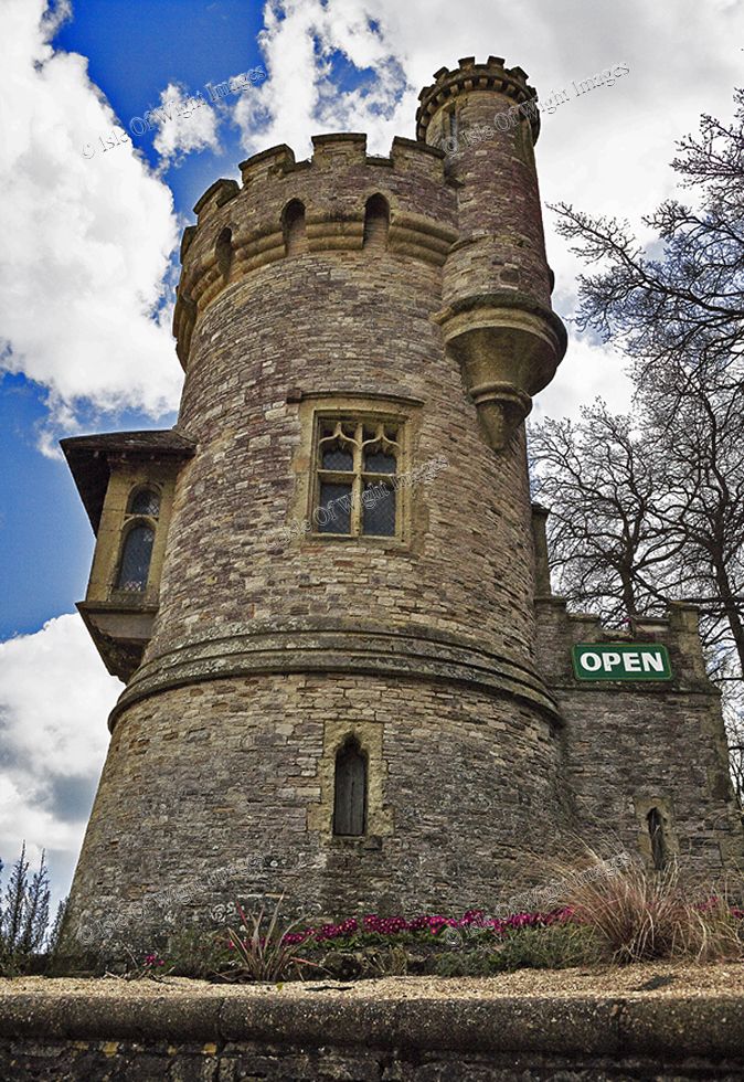 an old stone castle with a sign on the front and side windows that says open