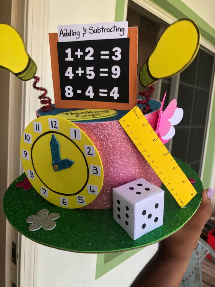 a person holding up a clock and some dices on a green surface with a sign that says adding 1, 2, 3, 4, 5, 6, 9, 8,