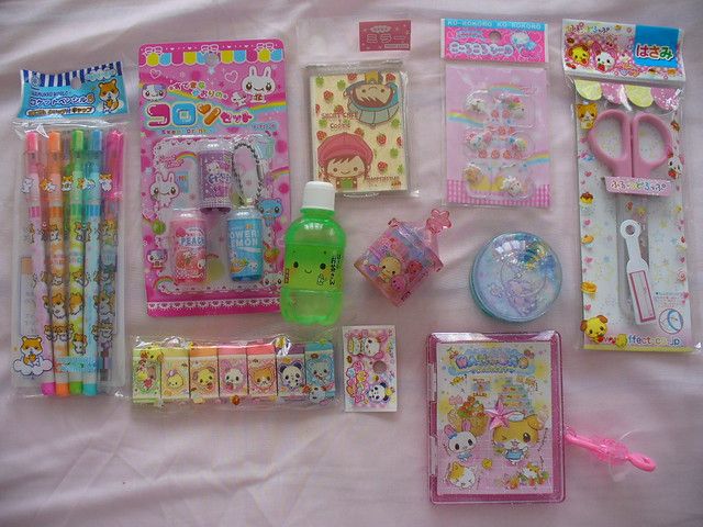 the contents of a hello kitty stationery set laid out on a bed