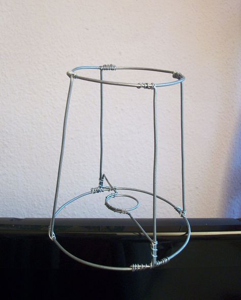 a metal object sitting on top of a black table next to a white wall and window