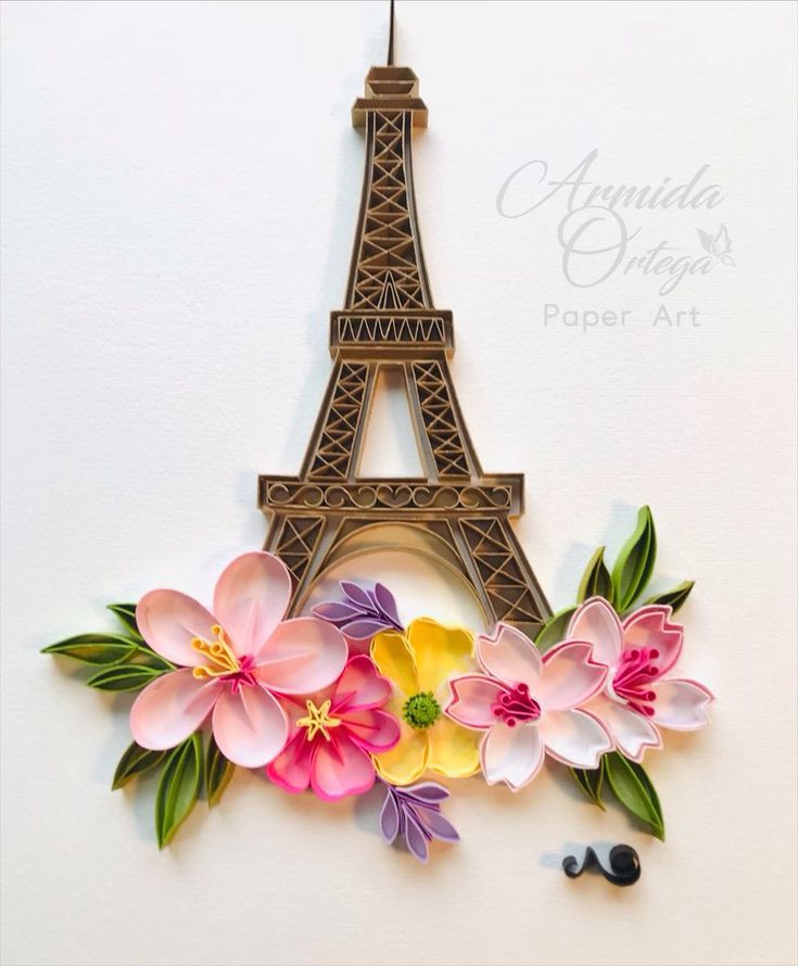 the eiffel tower is made out of paper and has flowers in front of it