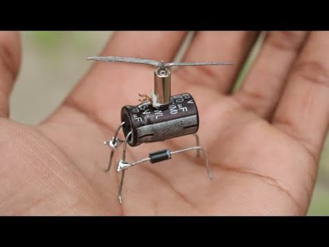 a tiny toy helicopter is being held in the palm of someone's left hand