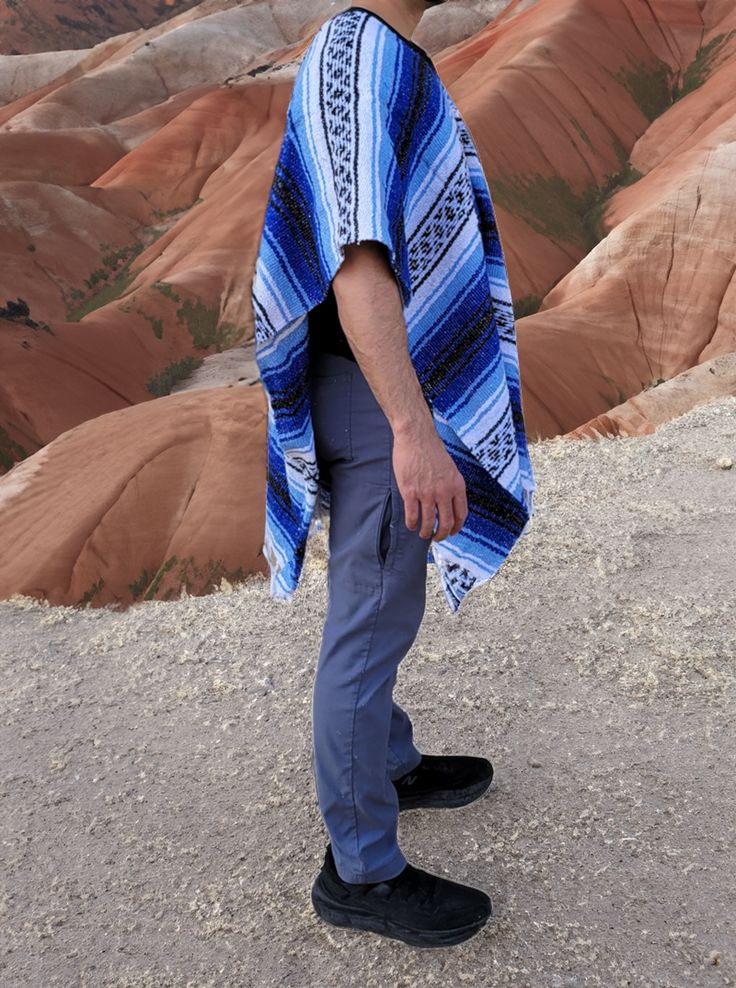 Material: Acrylic WoolColor: BlueStyle: Mexican Design: StripesSize:Length: 172cm (68")Width: 99 cm (39")It refers to the total measurements of the poncho when it is fully open (like a blanket). Description: MEXICAN PONCHOGenuine Mexican Poncho for Men manufactured in Mexico. The Mexican Poncho is an iconic and versatile garment that has been part of Mexican culture and tradition for centuries. The colorful and artisanal designs of GAMBOA adult ponchos make them a garment that not only expresses Poncho For Men, Mens Poncho, Artisanal Design, Mexican Designs, Mexican Culture, A Blanket, Put On, Your Style, For Men