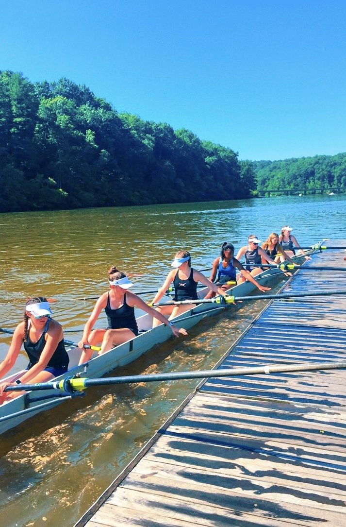 a group of people riding on the back of a boat down a body of water