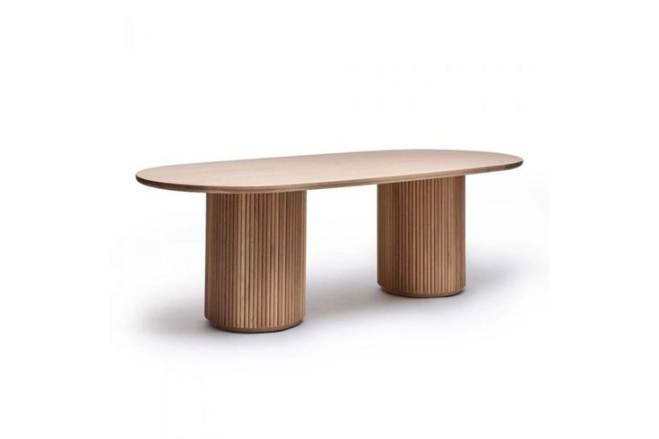 an oval wooden table sitting on top of a white floor