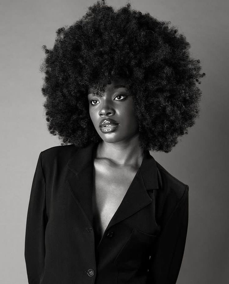 a woman with an afro is posing for the camera