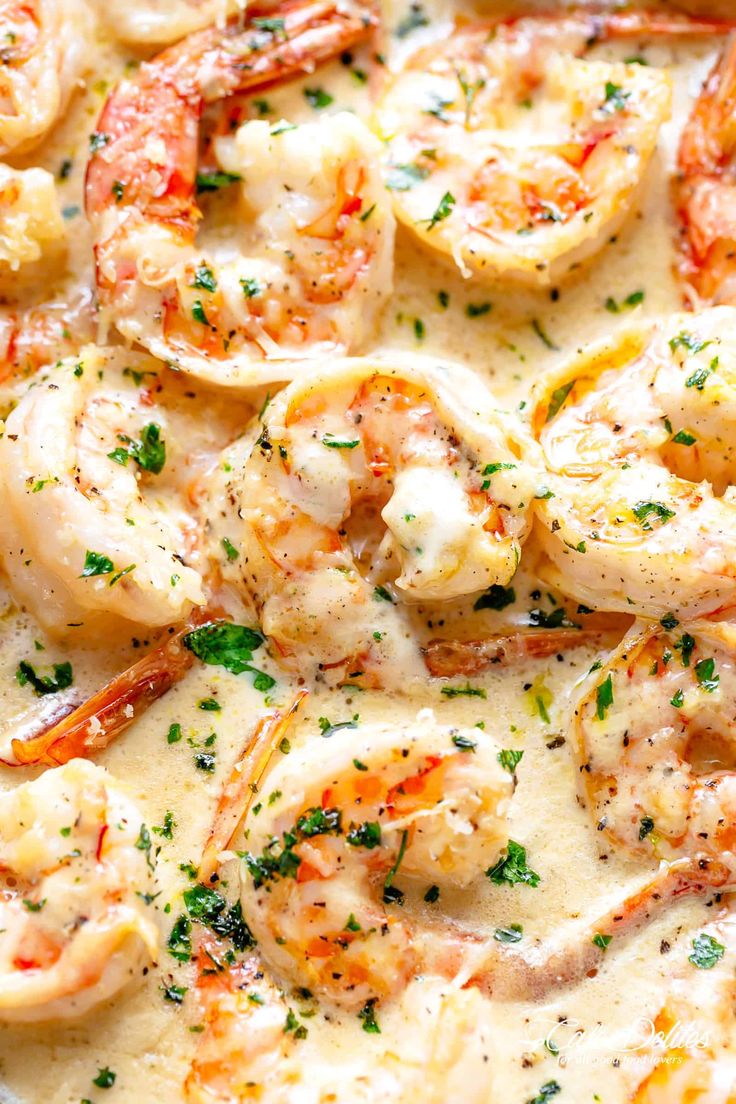 shrimp and grits in a white sauce with parsley on the side, ready to be eaten