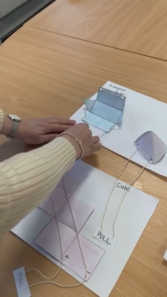 a woman is working on some paper with scissors and wire attached to the end of it