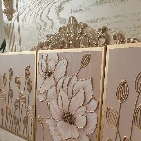 three panels with flowers painted on them in gold and pink colors, along with other decorative items