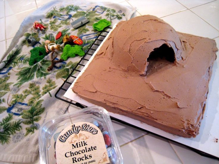 a chocolate cake sitting on top of a counter next to a container of frosting