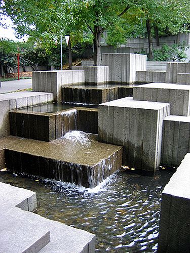 the water is running down the steps in the park, which are lined with concrete blocks