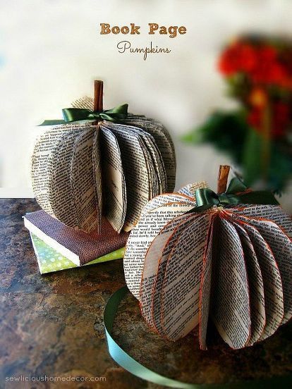 two book page pumpkins sitting on top of a table