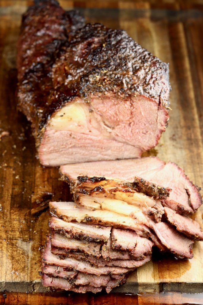 sliced up meat sitting on top of a wooden cutting board