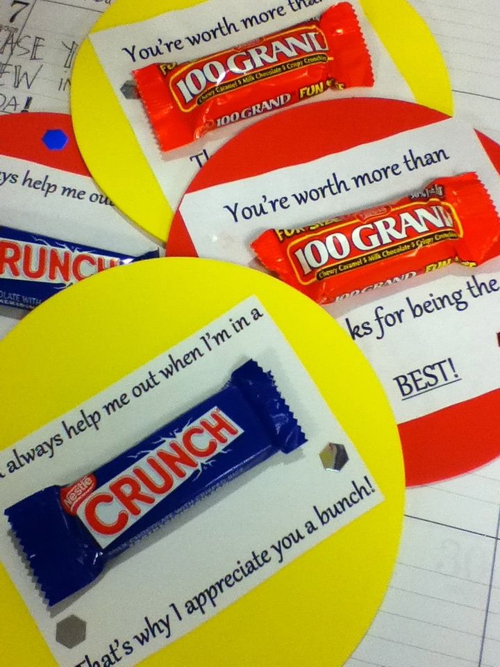 four personalized candy bars on top of lined up paper with writing in the background